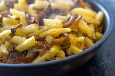 patates Cantharellus cibarius mantar ile bir tencerede kızartılır