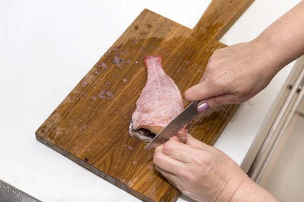 Frau zerschnitt den Barsch, kochte, fischte — Stockfoto