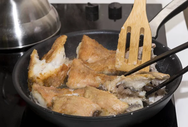 Шматочки риби смажені на сковороді, кухонне начиння, приготування — стокове фото