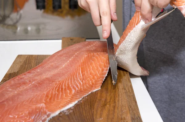Ragazza tagliare il filetto di salmone, coltello, pesce tagliere — Foto Stock