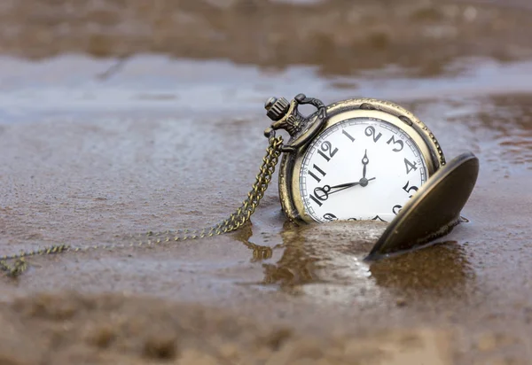 Orologio rotondo con le mani distese sulla sabbia bagnata, acqua, tempo — Foto Stock