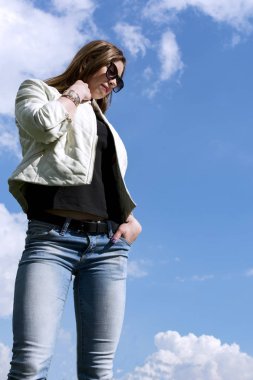 Kız bir beyaz deri ceket ve kot sk arka plan üzerinde