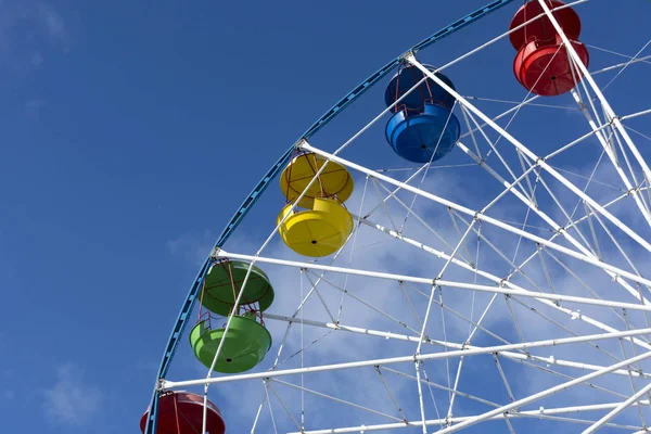 Riesenrad, gelbe, rote, blaue, grüne Buden, Sitze, blauer Himmel — Stockfoto