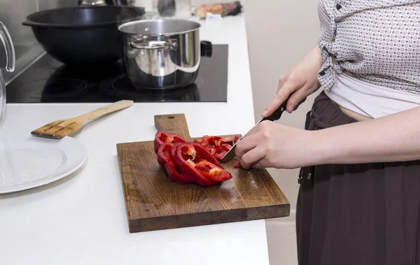 Девушка режет сладкий перец ножом, женщина готовит еду — стоковое фото