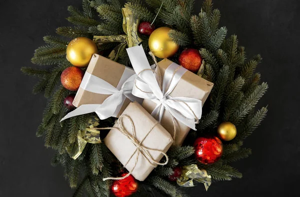 Karácsonyi ajándékdobozok fehér szalaggal egy fenyő koszorú — Stock Fotó