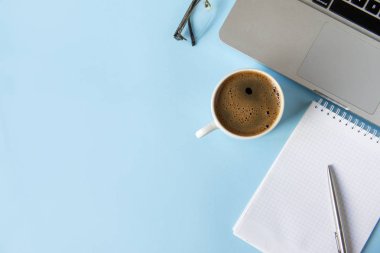 Temiz çarşaflı, dizüstü bilgisayarı, kalemi, kahve fincanı olan bir defter. 