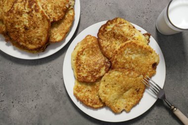 Gri arka planda iki tabak patatesli krep, bir bardak m