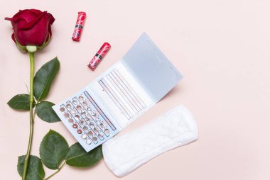 1 kırmızı gül, doğum kontrol hapları, pedler, bej sırt Grou üzerine tamponlar.