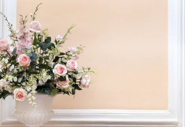 Bir buket pembe güllü vazo, yapraklı yeşil dallar.