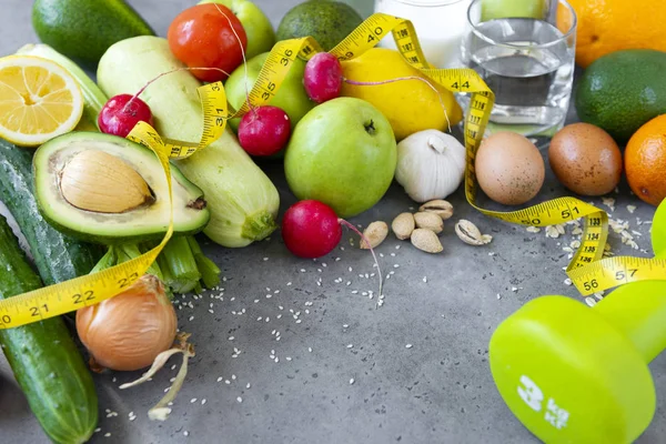 Verse groenten en fruit met een centimeter lint op een grijze b — Stockfoto