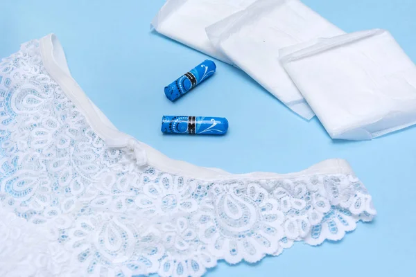 Culotte en dentelle, 2 tampons hygiéniques dans un emballage bleu, plusieurs coussinets o — Photo