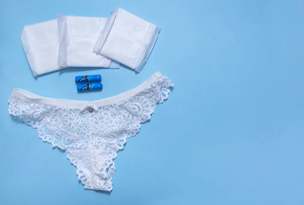 1 damskie białe koronki majtki, waciki higieniczne, podkładki na niebieskim plecach — Zdjęcie stockowe