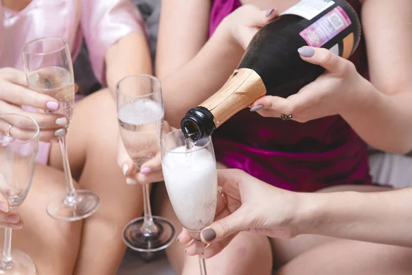 Kvinnors händer hälla champagne från en flaska i glas, alkohol — Stockfoto
