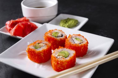 Beyaz tabakta havyarlı rulo, zencefilli Japon suşisi.