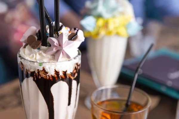 glass of sweet milkshake with whipped cream and chocolate, marsh