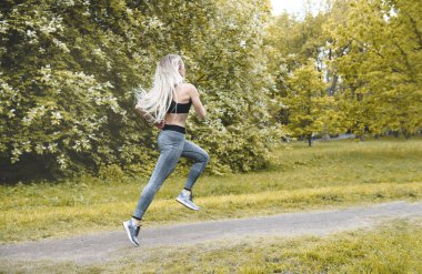 1 white young slim athletic woman running in the Park among the 