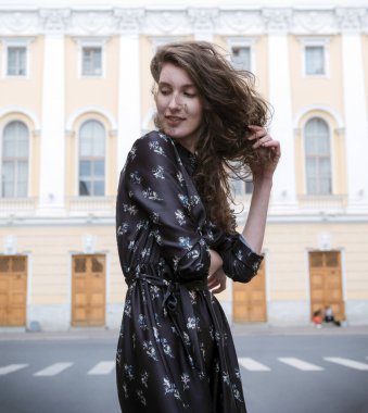 1 white young woman with brown wavy hair in a brown dress on the