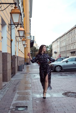 young woman, a girl in a long dress with long wavy hair walking 