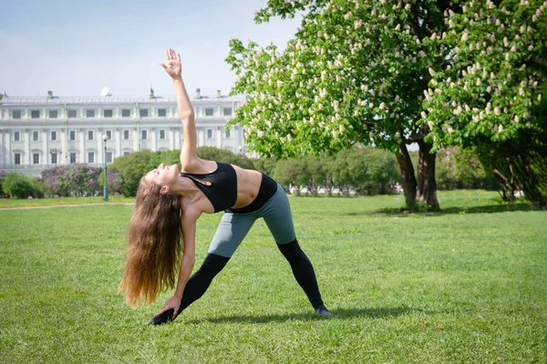 1 біла молода жінка з довгим волоссям займається спортом у парку — стокове фото
