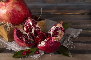 Tahta bir arka planda açık tohumlu olgun kırmızı nar.