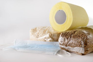 tuvalet kağıdı, karabuğday, yulaf gevreği, mısır gevreği, beyaz arka planda tıbbi maske, koronavirüs salgını
