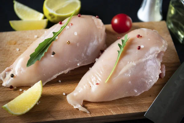 raw chicken fillet on the kitchen Board, tomatoes , lemon, herbs, meat