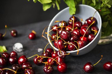 Gri arka planda nane aromalı olgun kırmızı kiraz tabağı, böğürtlen