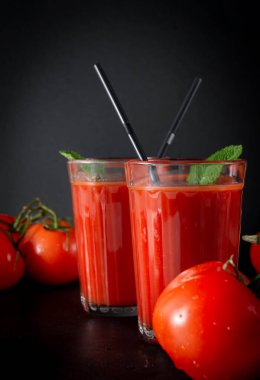 2 bardak naneli domates suyu, siyah arka planda taze kırmızı domatesler, fotokopi alanı.,