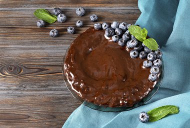 Yaban mersinli çikolatalı pasta ve siyah ahşap arka planda mavi havluya nane şekeri., 