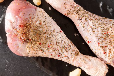 Siyah arka planda baharatlı 2 çiğ hindi bacağı, çiğ et, yakın plan.