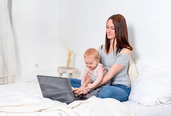 Bianco Giovane Madre Seduta Con Bambino Letto Lavorando Computer Portatile — Foto Stock