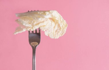 Yeşil zemin üzerinde bir çatal üzerinde 1 beyaz marul yaprağı