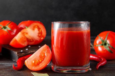 1 fincan domates suyu, taze kırmızı domates ve arka planda kırmızı biber, sebze suyu.