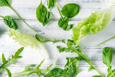 yeşil salata, taze ıspanak, beyaz ahşap arka planda roka.