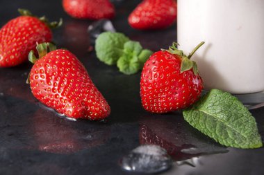 Taze kırmızı çilek, siyah arkaplanda nane.