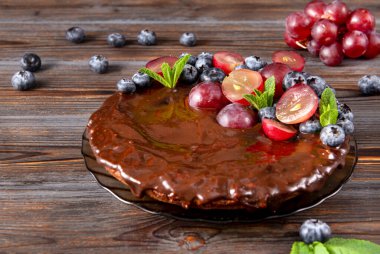 Böğürtlenli turta, taze yaban mersinli ve kırmızı üzümlü ev yapımı pasta, ahşap kahverengi arka plan manzaralı nane.