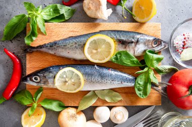 Baharatlı ve limon dilimli 2 çiğ uskumru balığı, biber, mantar, yağ, domates, fesleğen, sarımsak, soğan. 