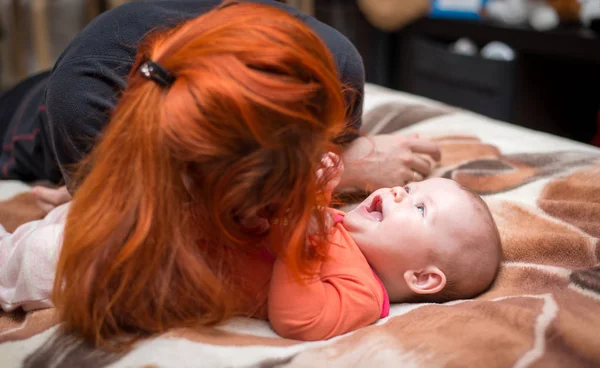 Matka s červenými vlasy hrající dítě a — Stock fotografie