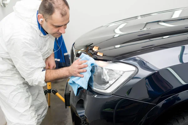 Muž na myčce aut leštící auto s leštícím strojem — Stock fotografie