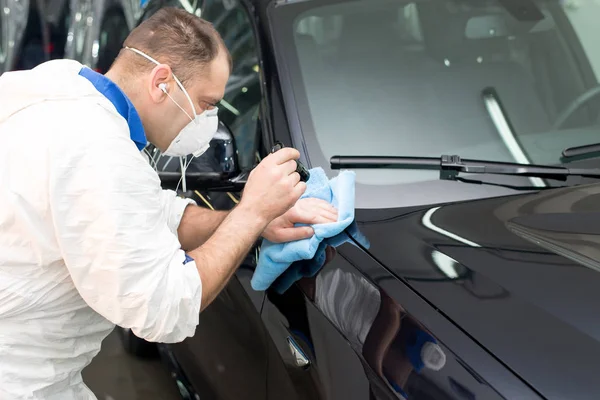 Muž na myčce aut leštící auto s leštícím strojem — Stock fotografie