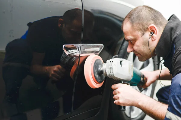 Muž na myčce aut leštící auto s leštícím strojem — Stock fotografie