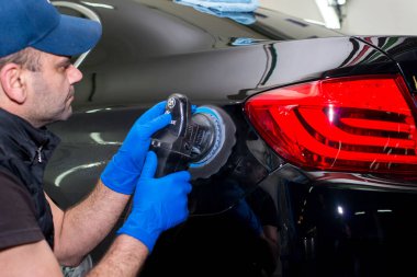 A man polishes a black car clipart