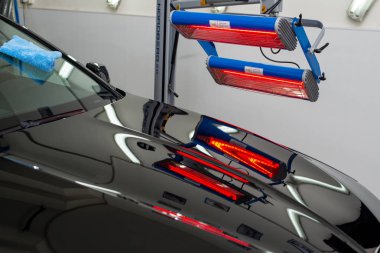 Bir adam siyah bir araba parlatır