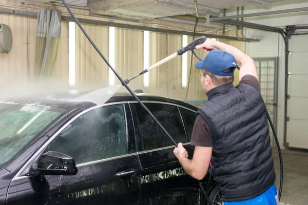 Człowiek Myje Czarny Samochód Pianki — Zdjęcie stockowe