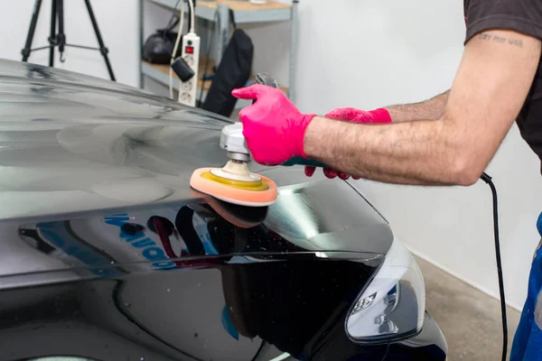 Een Man Polijst Een Zwarte Auto Met Een Polijst Machine — Stockfoto