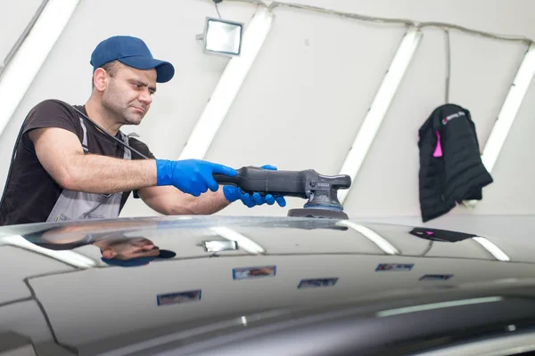 Un hombre pule un coche negro — Foto de Stock