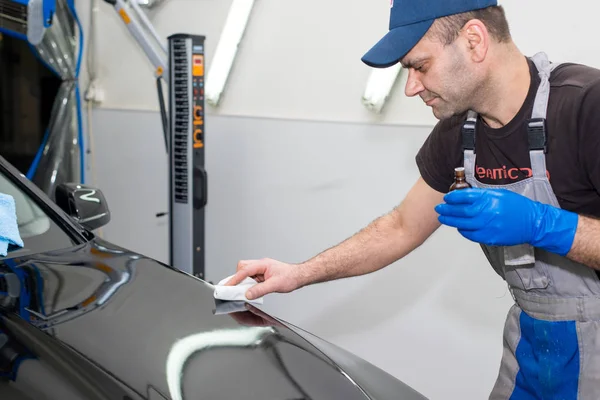 A man polishes a black car — Stock Photo, Image