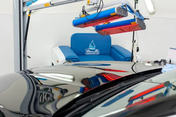 Bir adam siyah bir araba parlatır