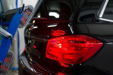 Bir adam siyah bir araba parlatır