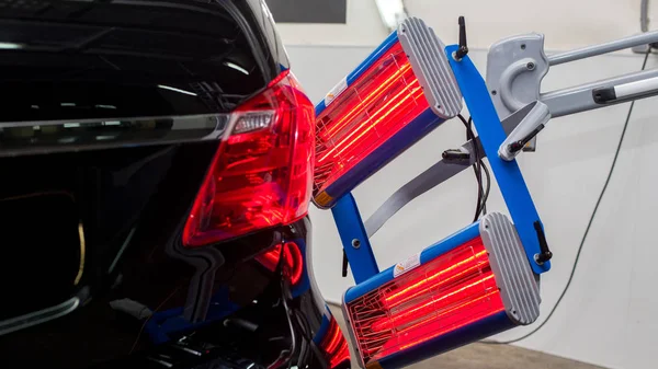 Bir adam siyah bir araba parlatır